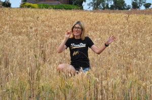 Laura Frankland enjoying the hot weather in a wheat field at Neenton, near Bridgnorth