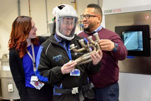 Iain Lyall, principal technician, dons a helmet, watched by teacher Staci Rutherford, from Telford Langley School, and mentor Lee Drummond from CADCOE.