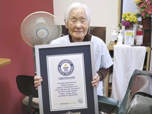 Shitsui Hakoishi, 108, poses with a Guinness World Records certificate recognising her as the world’s oldest female barber, at her shop in Japan