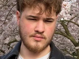 William Hewes close up in front of blossoming tree