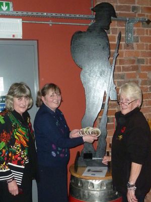Jean Parker and Margaret Edwards of Ludlow Memorial Fund with Andrea Walters (representing Gary and Alison Walters of Ludlow Brewery) with the beer mats and a “shadow soldier”.