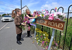 Lottie Hutchinson, aged 6 and Sienna Wain, aged 8, friends of the girl who was killed, lay flowers at the scene
