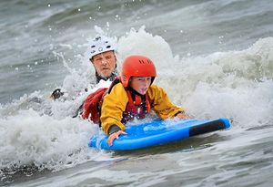 Outdoor educator Matty Bowman surfing with pupils from John Randall Primary School