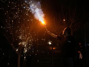 A man holds a flare