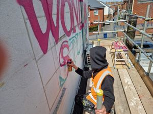 Stourbridge artist Cal up on the scaffolding creating the Wonder Stuff artwork