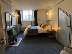 Blue bedroom with quirky door, made to fit between original beams.
