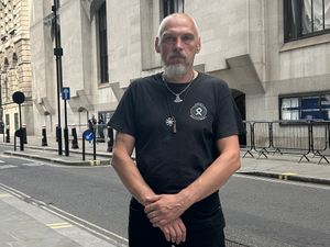 Piotr Kucharski posing outside the Old Bailey wearing articles associated with extreme right-wing ideology