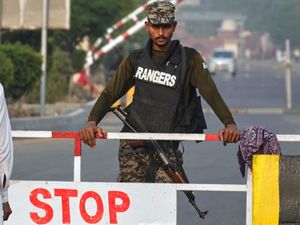 A Pakistani soldier with a weapon standing next to a checkpoint