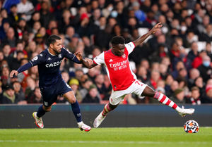 Aston Villa's Douglas Luiz (left) and Arsenal's Bukayo Saka battle for the ball
