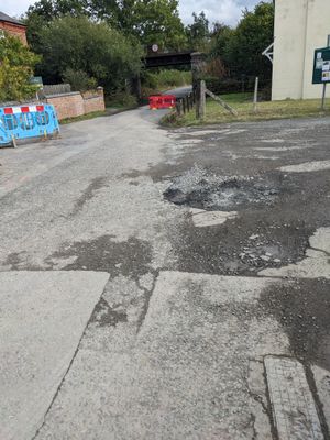 The road has been left pot holed