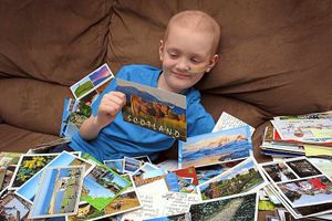 Joshua surrounded by some of his well wishing postcards that have flooded in from people around the globe.