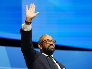 James Cleverly waves from the stage of the 2024 Conservative Party conference
