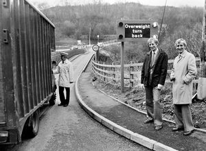 Coalport Bridge on April 21, 1983. The caption reads: 'A weight detector system came into operation yesterday at Coalport Bridge across the River Severn. It is the first of its type in Britain and has been developed by the Transport and Road Research Laboratory and activates an illuminated sign to weigh vehicles at each approach to the bridge. Watching Inspector Roger Jenks with the driver of an overweight vehicle are Trevor Stevenson (left), chief engineer of Telford Development Corporation, and Keith Madelin, Shropshire County Council surveyor.'