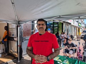 Adil Iqbal Malik, a British Pakistani lawyer, posing in front of a vegetable stall