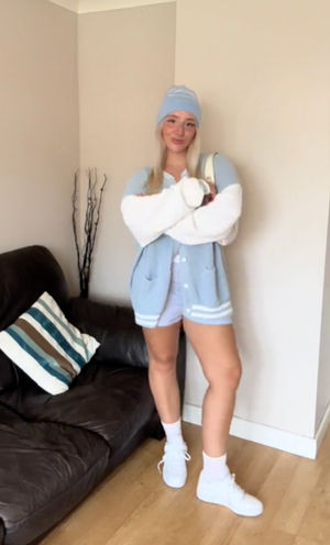 Abbie Fidgett, 22, partners boxer shorts with a blue beanie and varsity jacket, October 2023. See SWNS story SWNJouterwear. A woman wears underwear as "outerwear" to overcome her body dysmorphia - and dons lingerie, corsets and boxers to go to the beach and on nights out. Abbie Fidgett, 22, began suffering from body dysmorphia after she was bullied throughout school and college. She spent 20 weeks on a waiting list for cognitive behavioural therapy (CBT) and refused to go back to the GP after they wanted to weigh her.