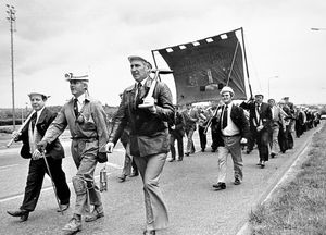 This was taken on June 29, 1979. Written on the back is 'miners march.' Over 200 miners from Granville Colliery at St Georges, led by colliery manager, Mr Colin Rigby, marched from Madeley Court Centre to Blists Hill Museum to present their miners' banner to the museum. The presentation of the banner officially marked the closure of the pit, although work was still to continue until August 1979. On arrival at Blists Hill there was a pithead service when the miners assembled at St Chad's Miners' Mission Chapel to mark the handing over of the banner, which was received by Neil Cossons of Ironbridge Gorge Museum, from miners' lodge secretary Herbie Hirst. Herbie Hirst is identifiably far left. 