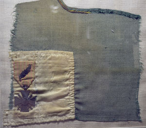 The original Croix de Guerre avec Palme attached to the only fragment of flag which survived an IRA firebomb attack.