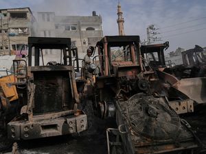 Palestinians examine the remains of bulldozers hit by an Israeli army airstrike in Jabaliya, northern Gaza Strip