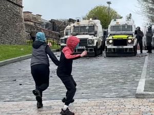 Youths throwing rocks towards police in the Bogside area of Derry