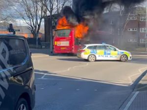 The bus could be seen well ablaze as police blocked the road. 