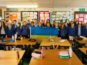 School pupils hold up a Ukrainian flag