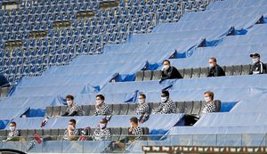Frankfurt's team members, keeping a distance, sit in the stands during the German Bundesliga soccer match between Eintracht Frankfurt and Borussia Moenchengladbach in Frankfurt, Germany, Saturday, March 16, 2020. The German Bundesliga becomes the world's first major soccer league to resume after a two-month suspension because of the coronavirus pandemic. 