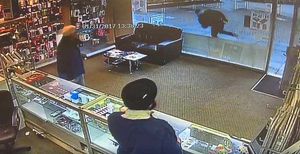 The man is captured running by the window of the shop