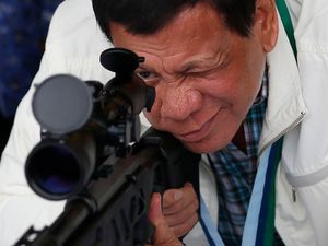 Rodrigo Duterte checks the scope of a sniper rifle