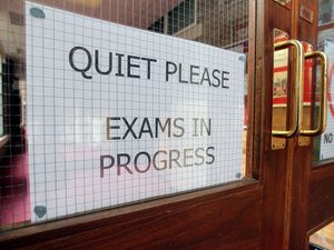 A sign on a door which reads 'exams in progress'
