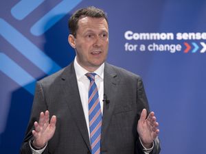 Russell Findlay speaking in front of Scottish Tory signage