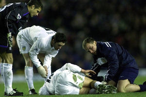 Leeds United's Stephen McPhail lies on the floor injured as team-mate Robbie Keane and physio Dave Hancock 