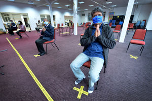 Hasmukh Patel and other trustees sit in the main hall, which has socially-distanced markings on the floor
