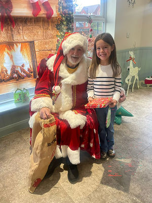Resident Alan Bowater as Santa with child at HC-One’s Sedgley Court Care Home’s Christmas candy cane cavern