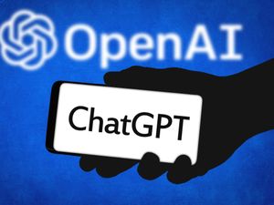 A hand holding a mobile saying ChatGPT with the OpenAI logo in the background