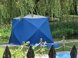 A tent was seen between the river and the children's play area