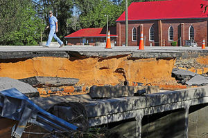 A man walks across a road damaged by floodwaters caused by rain from Hurricane Matthew in North Carolina