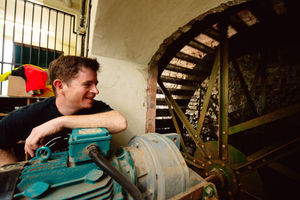 Josh Crouch with the waterwheel and generator which feeds electricity into the National Grid