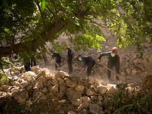 First responders dig for bodies at the site of a mass grave in Raqqa