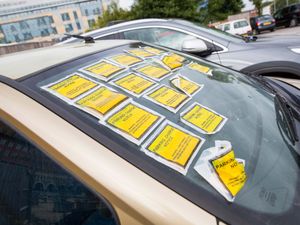 Several parking charge notices on a car windscreen