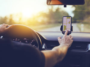 Man, touches sat nav as he plans his next journey.