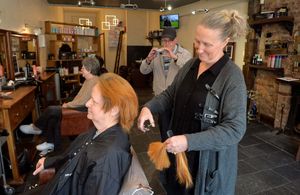 Pat Hirst having her head shaved to raise money for Macmillan Cancer Support. Doing the chopping was Jo Williams.