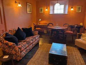 The earth-red living room of Flat 2, The Retiring Rooms.
