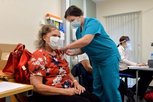 Dr Laura Land, who is taking time out of her maternity leave, vaccinating Maureen Bond, 82