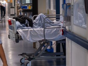 A patient on a bed in a hospital corridor