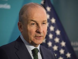 Headshot of Micheal Martin in front of a US flag