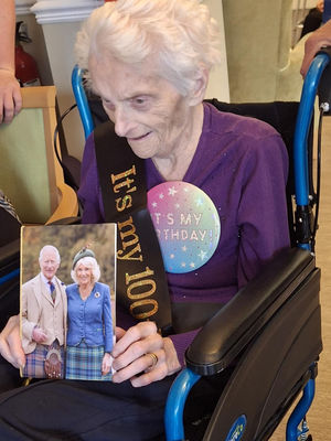 Resident, Irene Weaver at HC-One’s Roxburgh House Care Home celebrating her birthday with card from the King and Queen