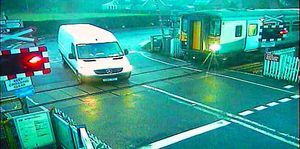 The van drives over the railway line, just feet from the train that had managed to come to a stop, preventing a serious accident