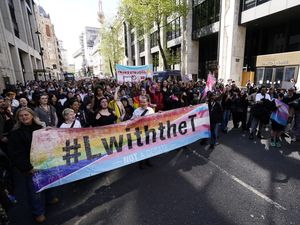 Campaigners march past the Department for Work and Pensions after a rally to support trans rights in London