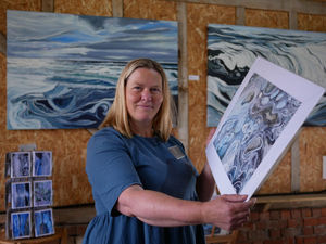 Crossgates Artist Lucy Burden holding a print of her work titled 'Cat Ice'