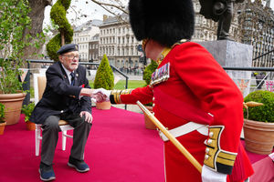 Second World War veteran Alan Kennett shakes hands with a member of the Band of the Irish Guards, near Parliament Square, central London, ahead of a military procession. Credit: Jeff Moore/PA Wire